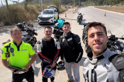 Motosikletini bağlayan polis ile fotoğraf çektirdi