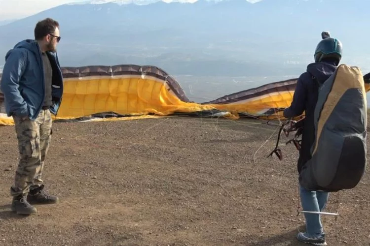 Bursa'da yamaç paraşütü yapan arkadaşlarını uçaktan selamladı